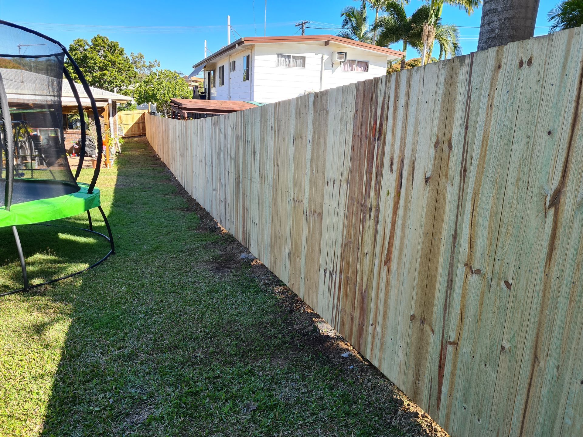 A Tall, New Wooden Fence Runs Along a Green Backyard Lawn — PROFENCE AND RETAINING in Beecher, QLD