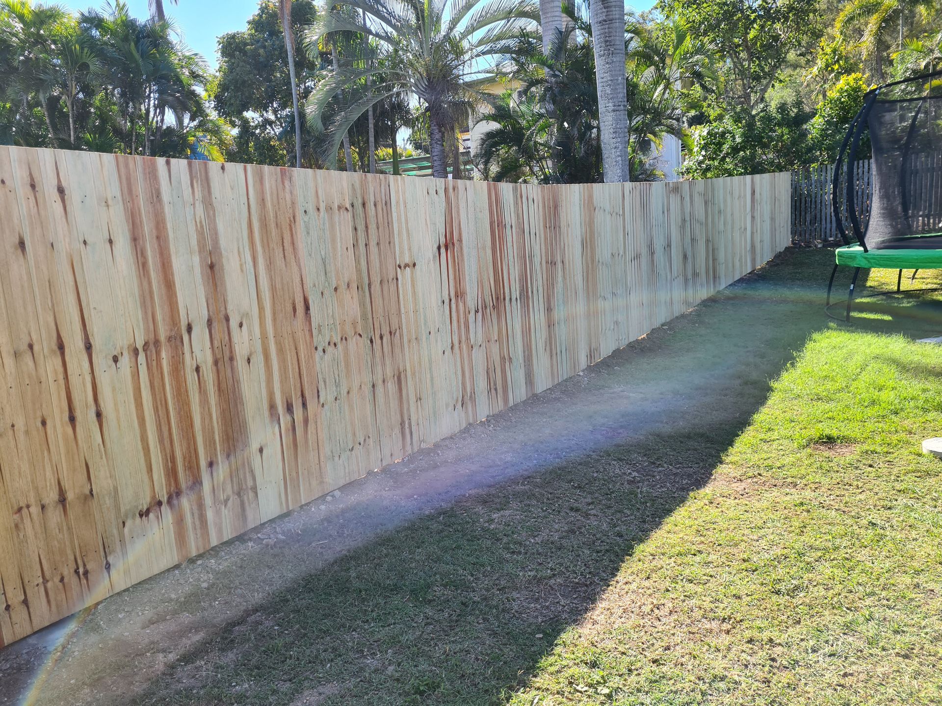 A Long, Newly Installed Wooden Fence Made of Vertical Pine Planks — PROFENCE AND RETAINING in Beecher, QLD
