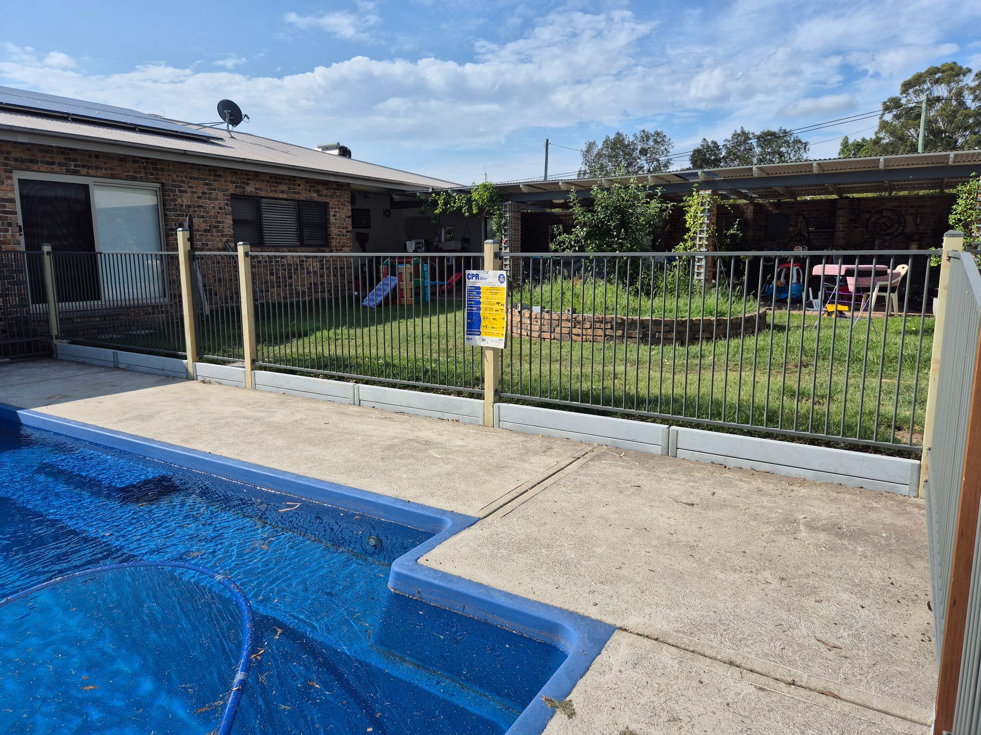 A Backyard Pool With a Blue Cover Next to a Concrete Patio — PROFENCE AND RETAINING in Beecher, QLD