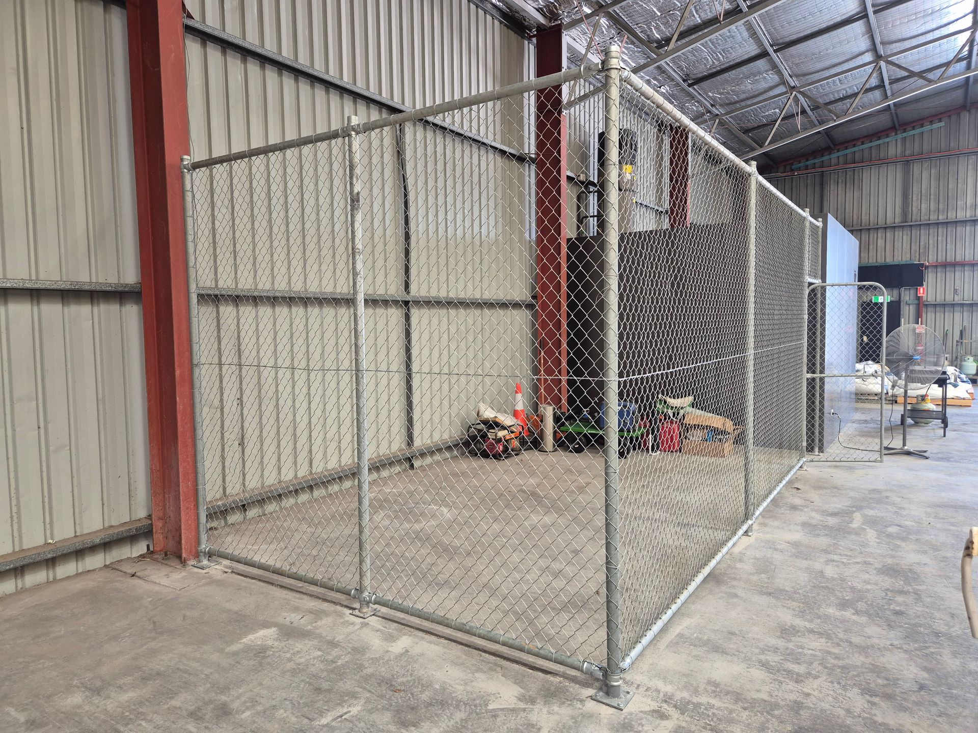 A Metal Chain-link Enclosure Sits on a Concrete Floor — PROFENCE AND RETAINING in Beecher, QLD