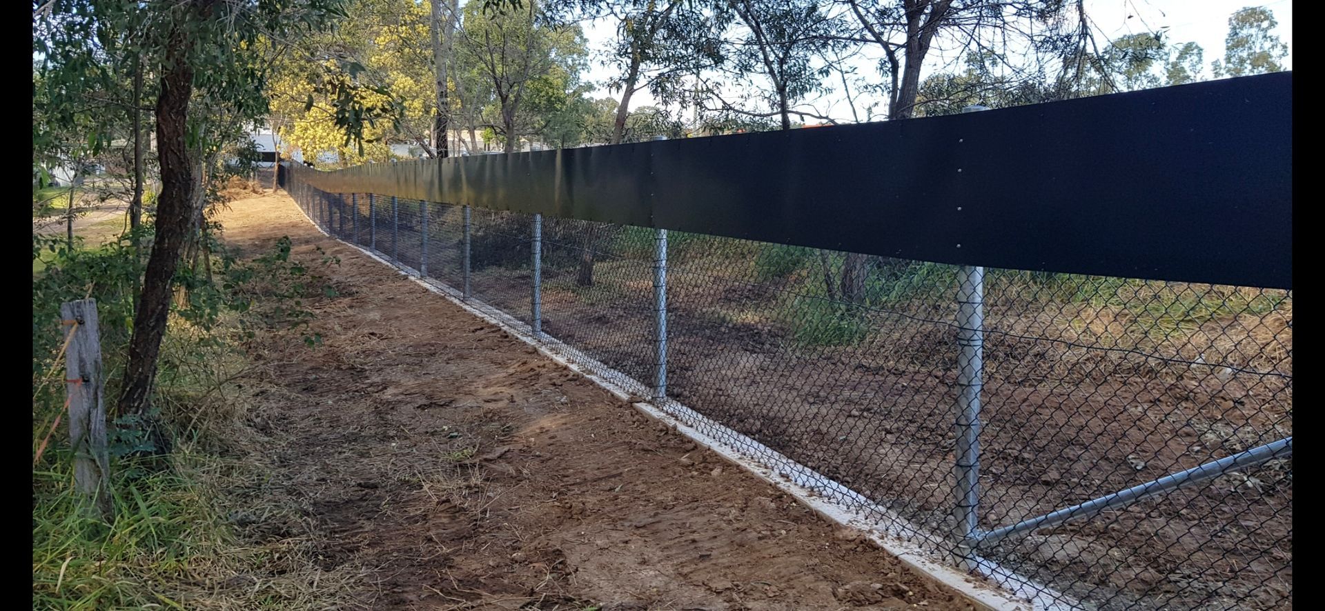 A Long, Wire Mesh Fence With a Solid Black Panel Top and Concrete — PROFENCE AND RETAINING in Beecher, QLD