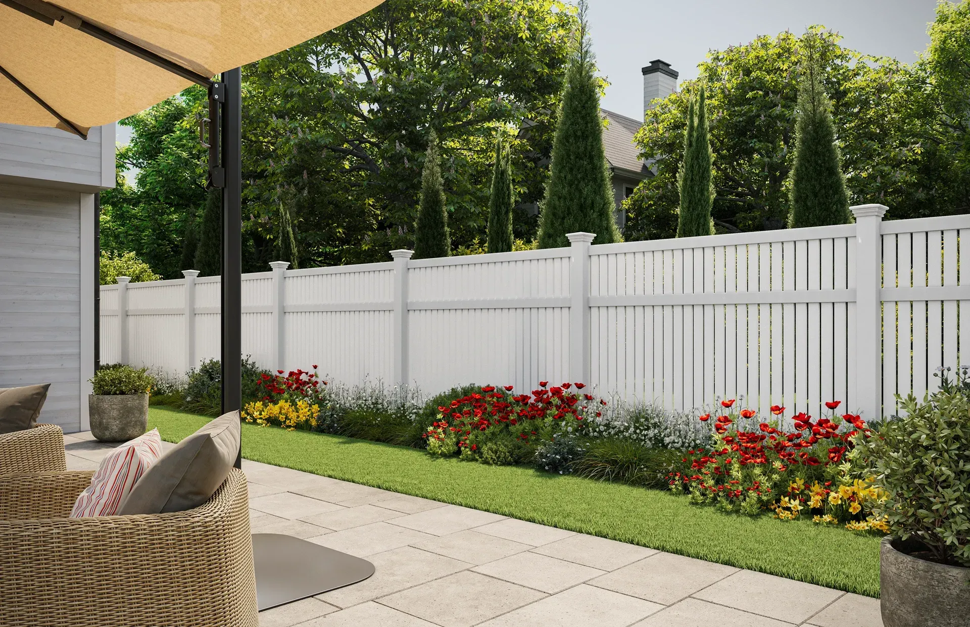 Patio with white fence, flowers, and umbrella.