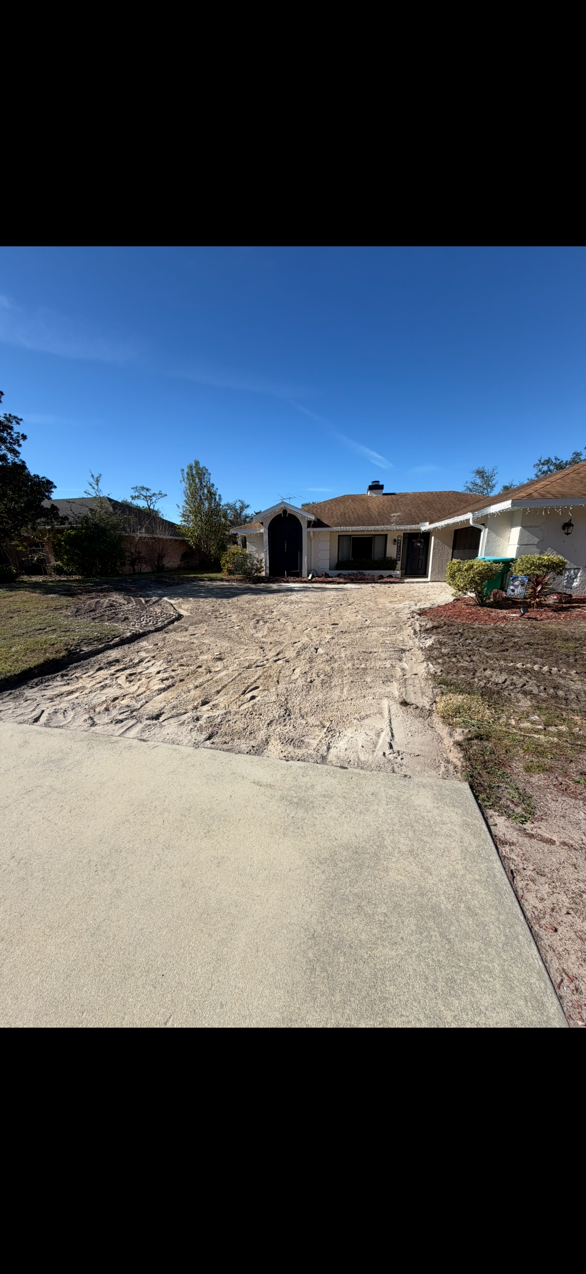 House with a driveway under construction. Blue sky.