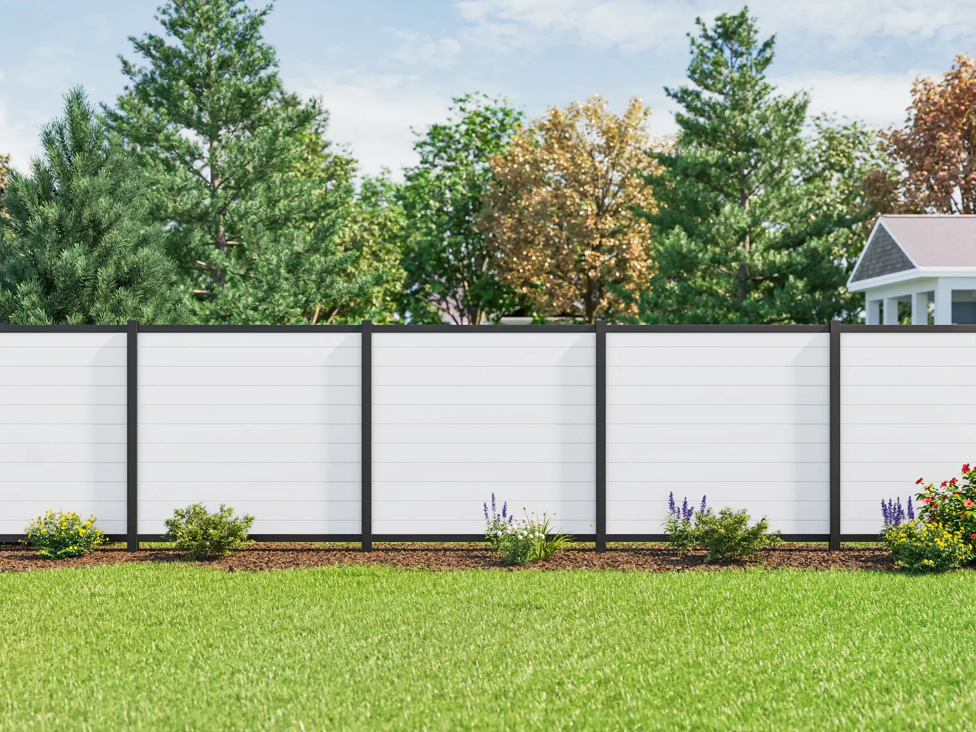White and black modern fence in a yard with green grass and trees.