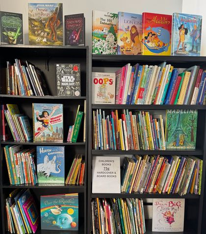 Two tall, black bookshelves filled with colorful children's picture books arranged on five shelves each.