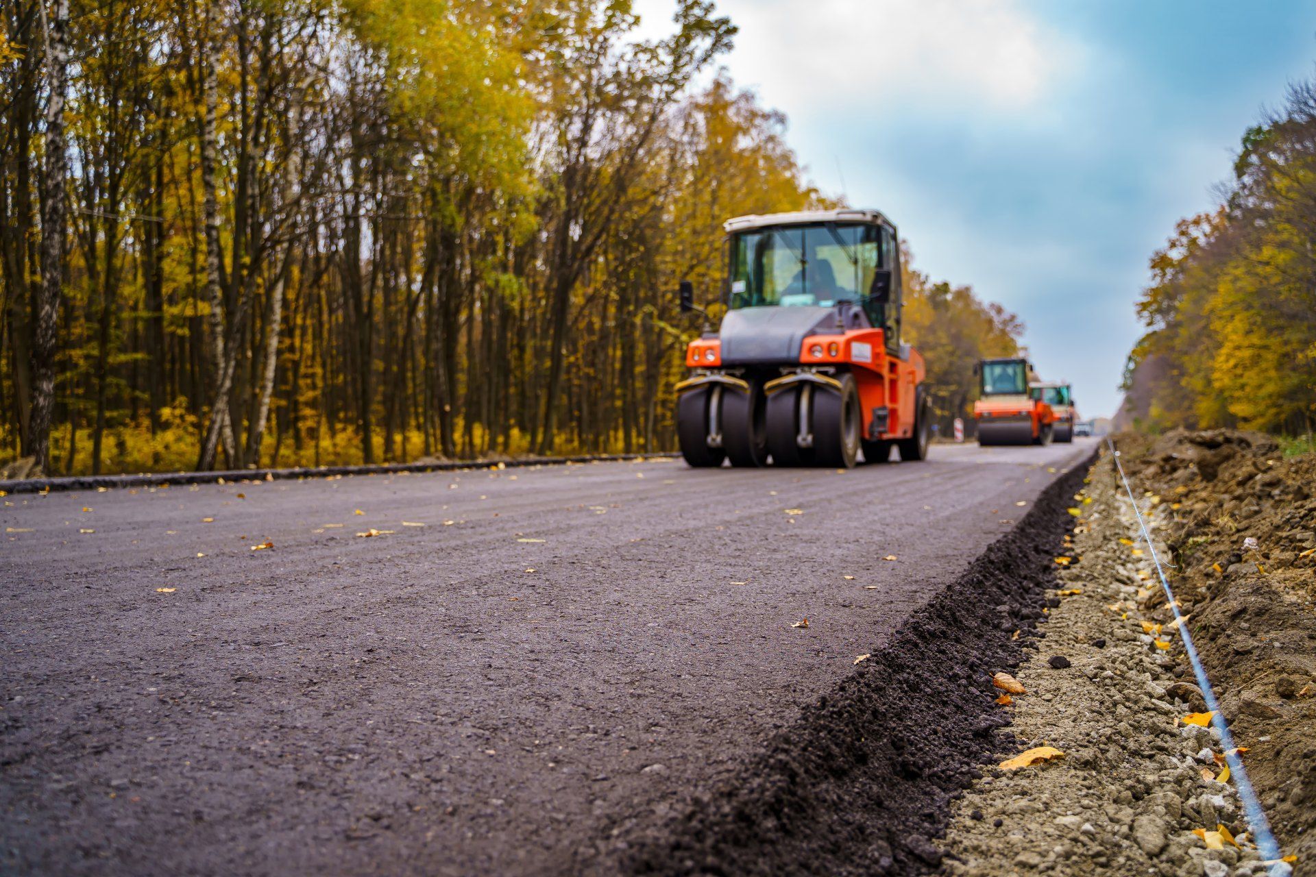 A couple of tractors are driving down a road.