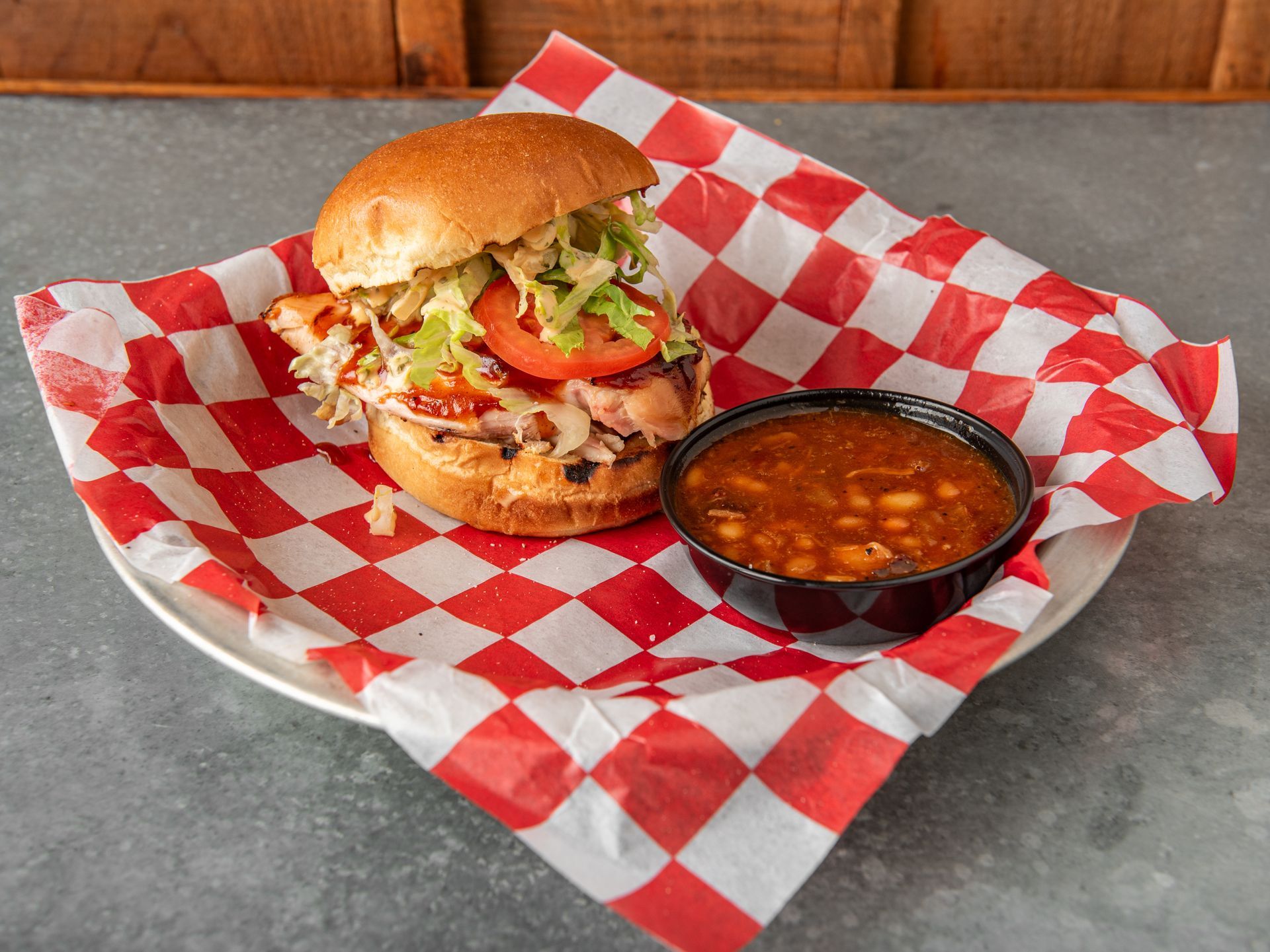 A banana pudding parfait on a red and white gingham parchment paper