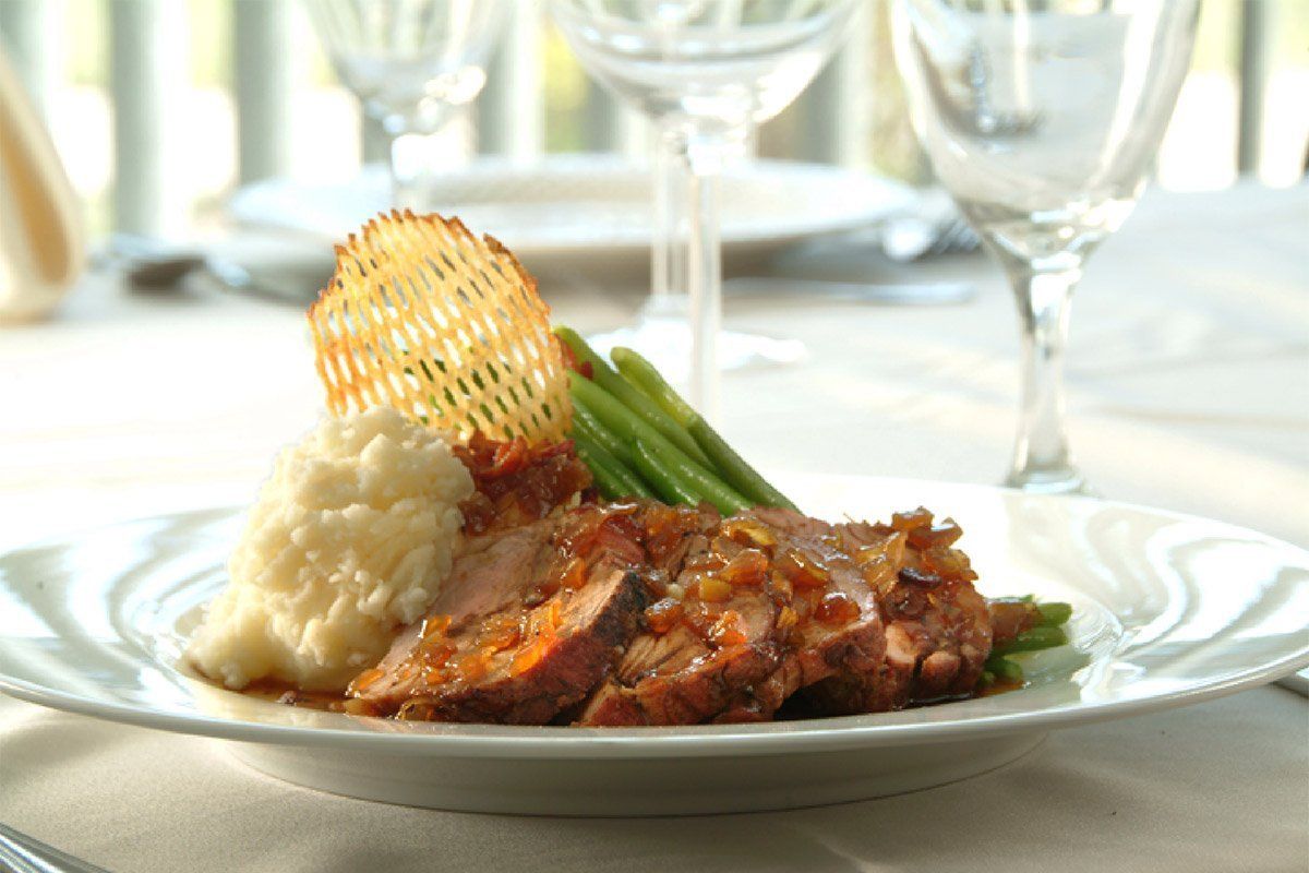 A white plate topped with meat mashed potatoes and green beans