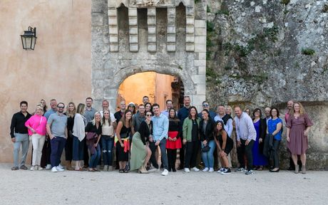 A large group of people are posing for a picture in front of a building.