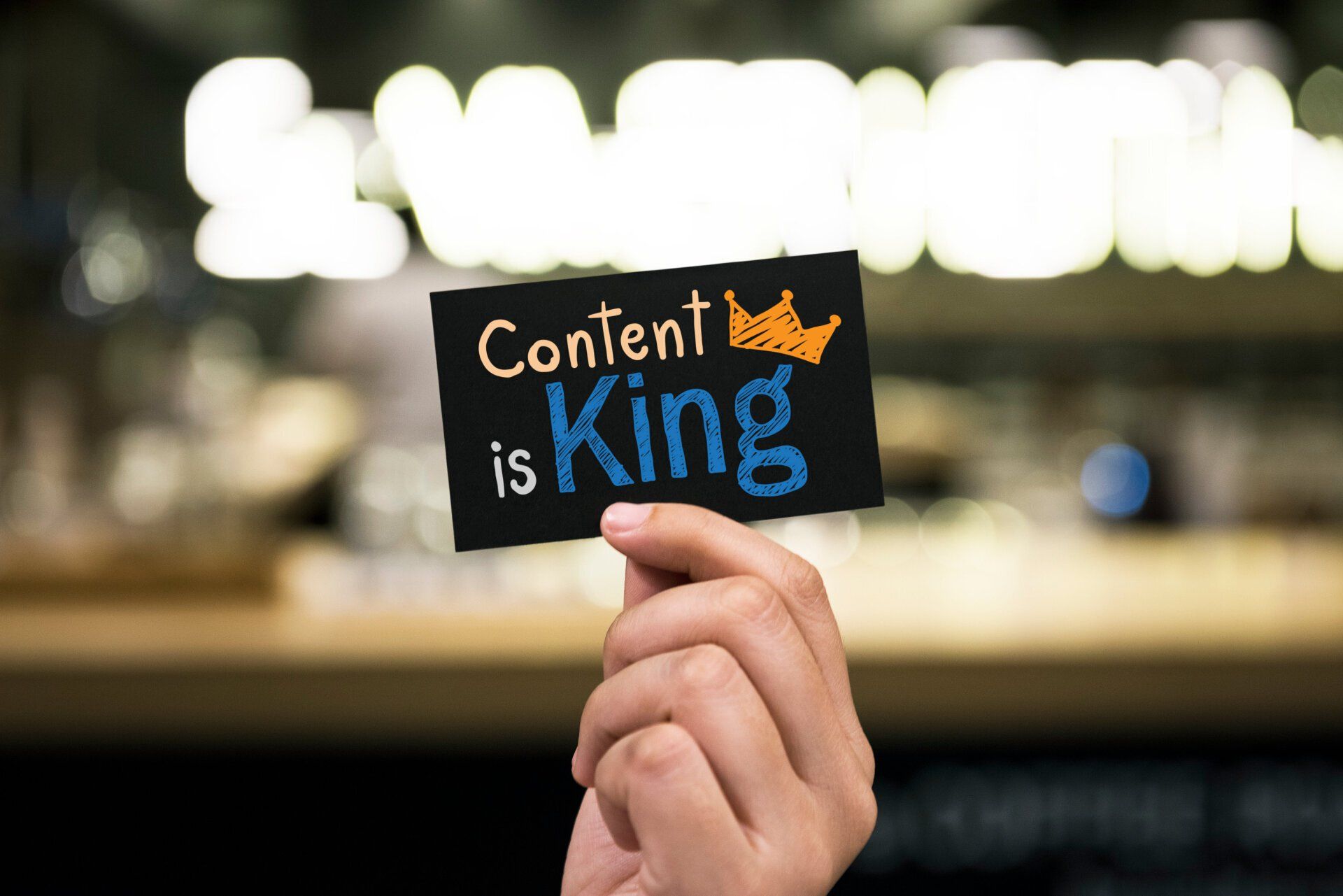 a hand holding a card that says content is king