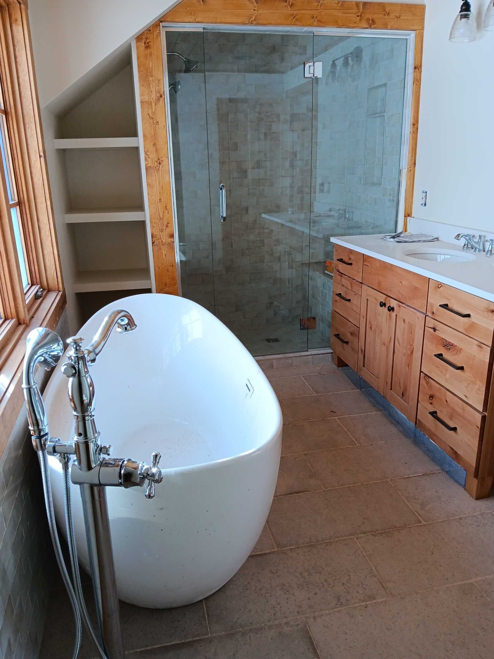 A bathroom with a bathtub and a glass shower door