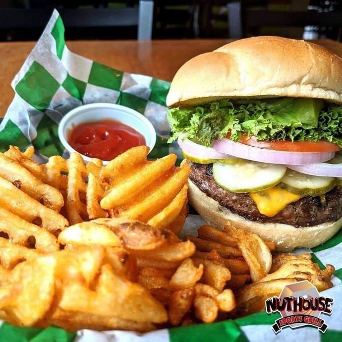 A hamburger and french fries are on a green and white checkered table cloth.