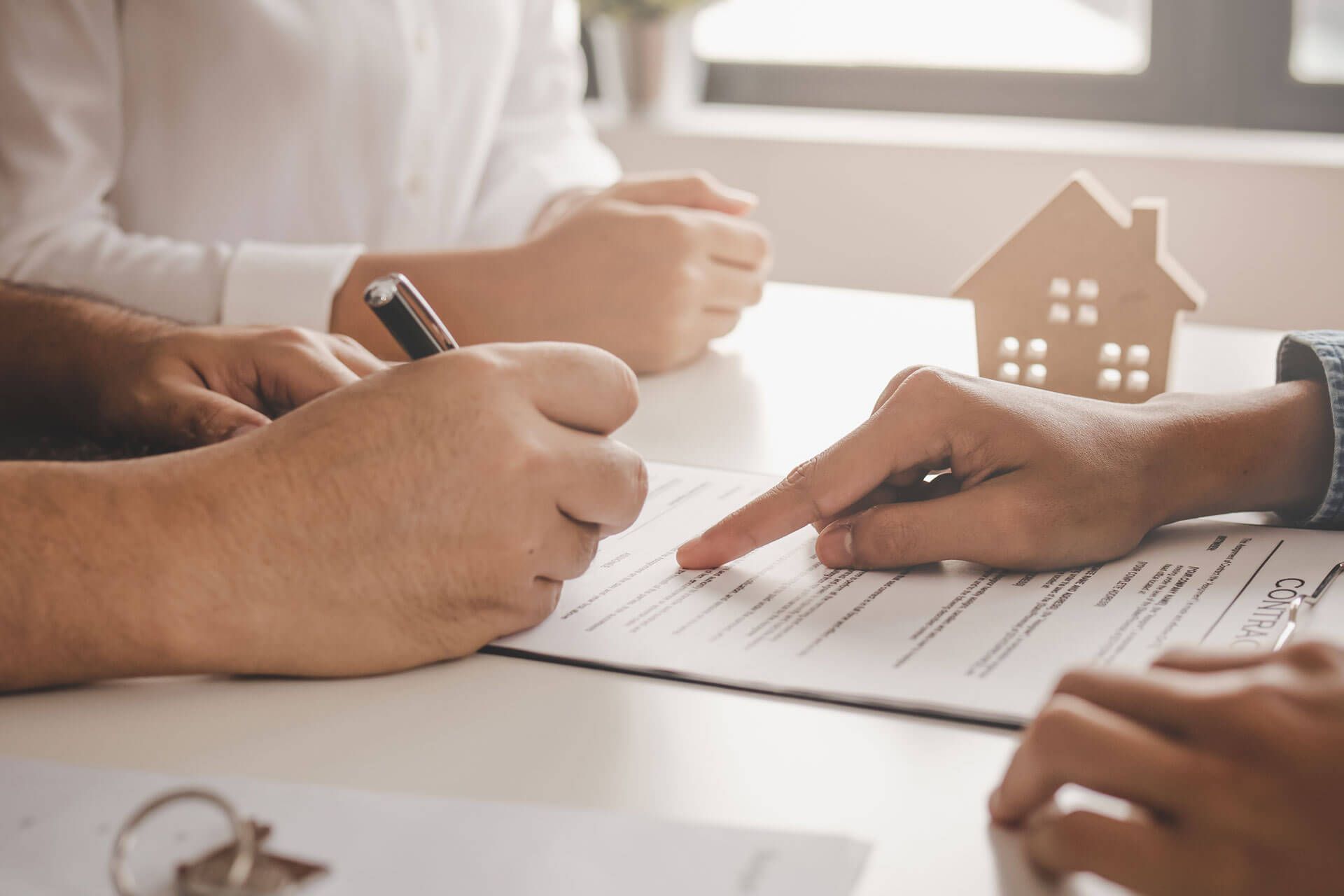 A group of people are sitting at a table signing a document.