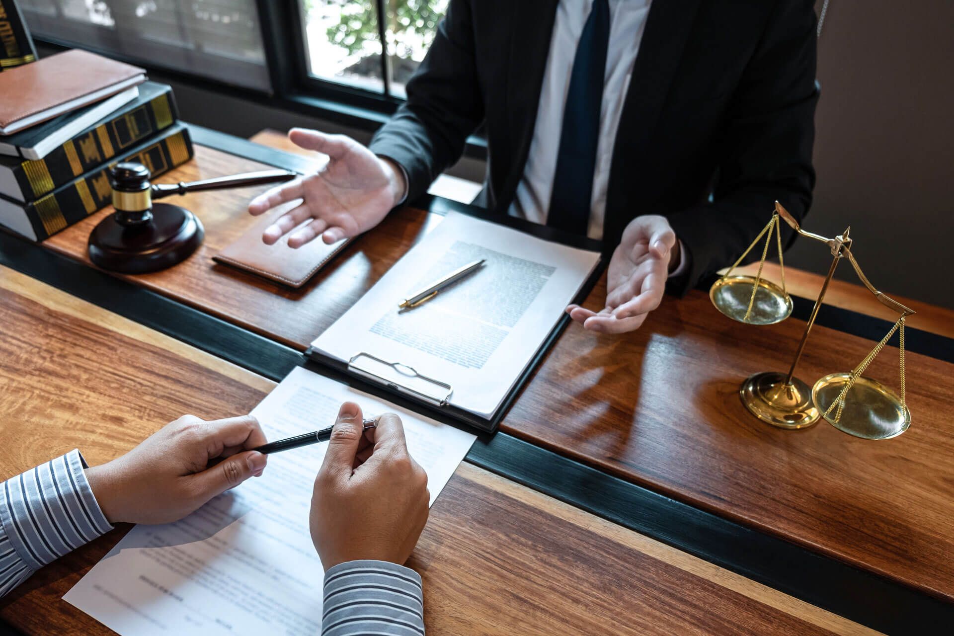 A lawyer is sitting at a desk talking to a client.