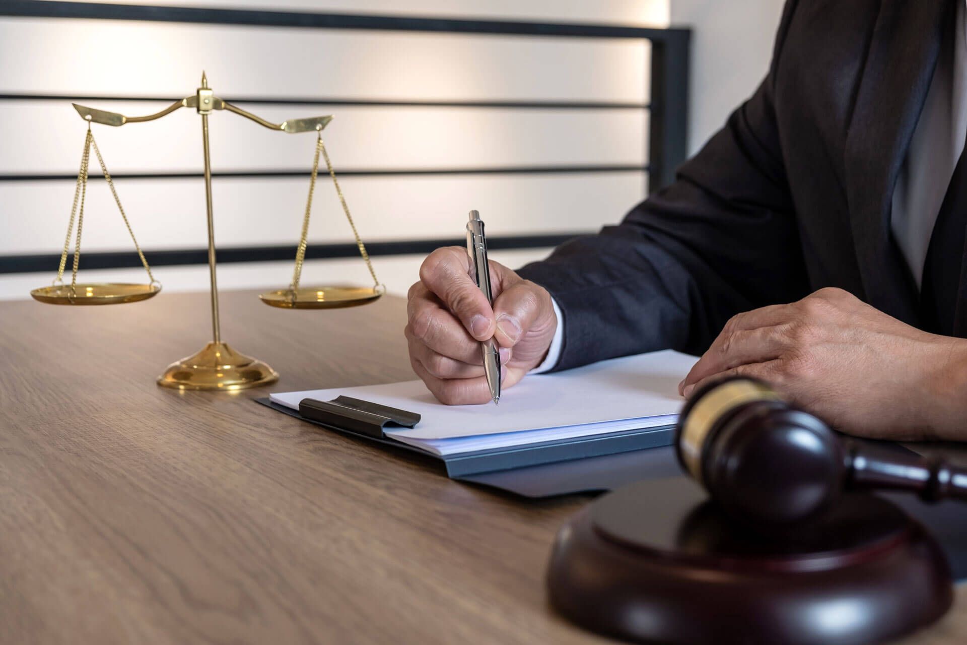 A judge is sitting at a table writing on a clipboard.