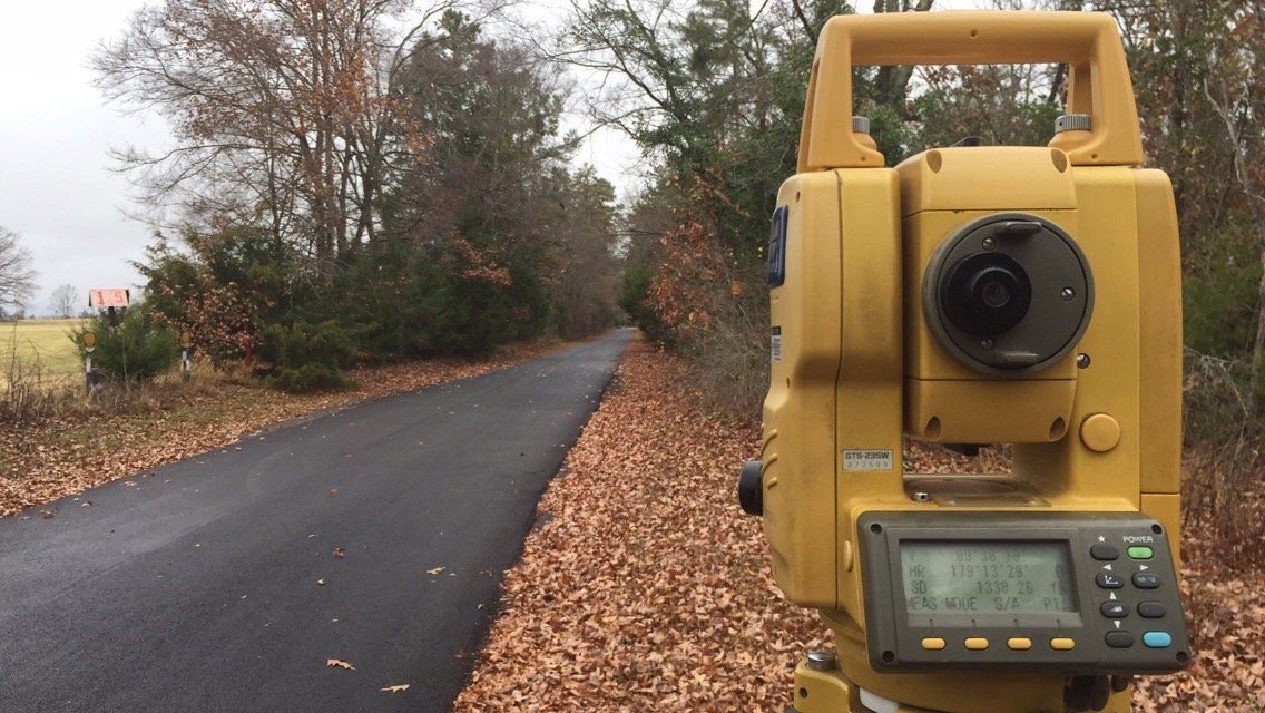 A total station is sitting on the side of a road.