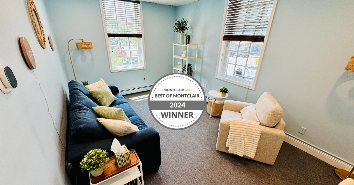 Therapy room with a navy couch, beige chair, windows, and a "2024 Winner" badge.