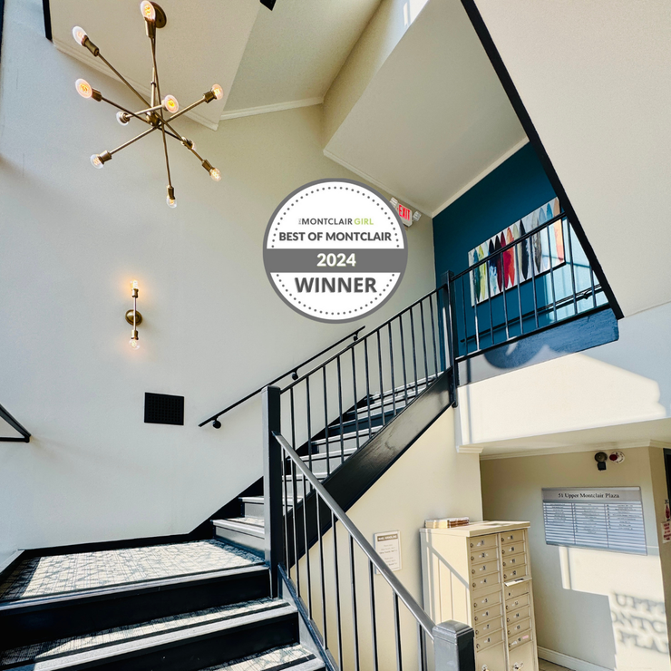 Stairwell with black railing, white walls, black and white tiled steps. 2024 Best of Montclair winner badge.