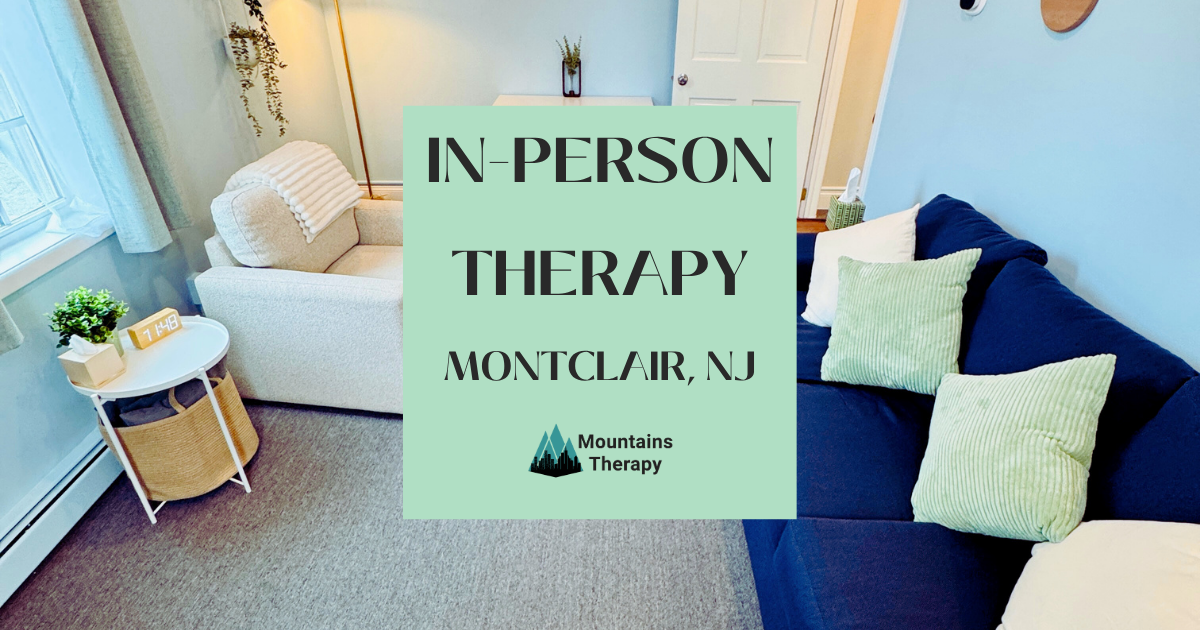 Cozy therapy room: blue walls, navy couch, white chair, window, text