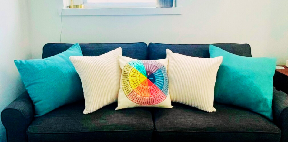 Dark gray sofa with teal and patterned pillows.