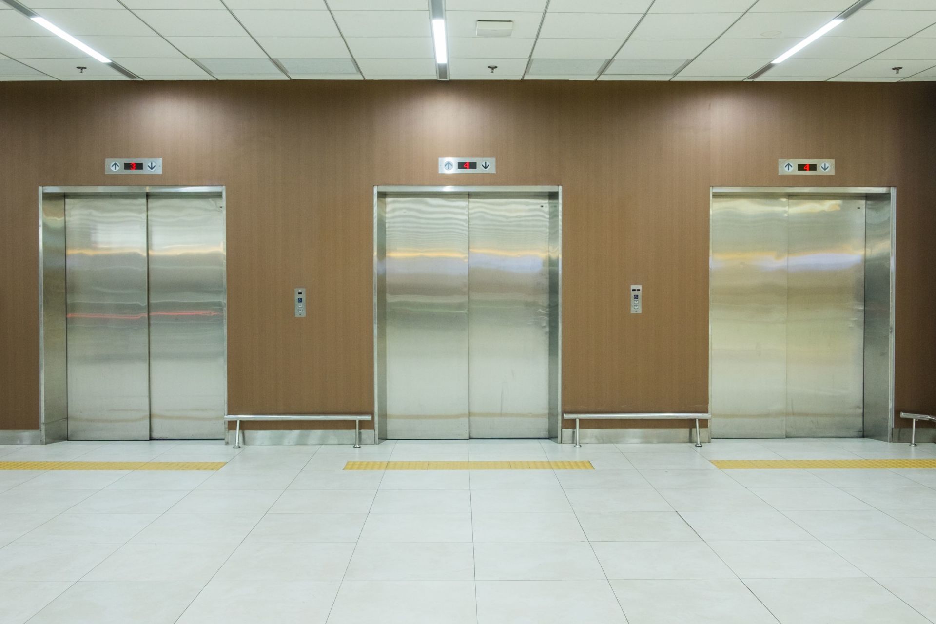 Tre ascensori sono allineati in fila in un edificio.