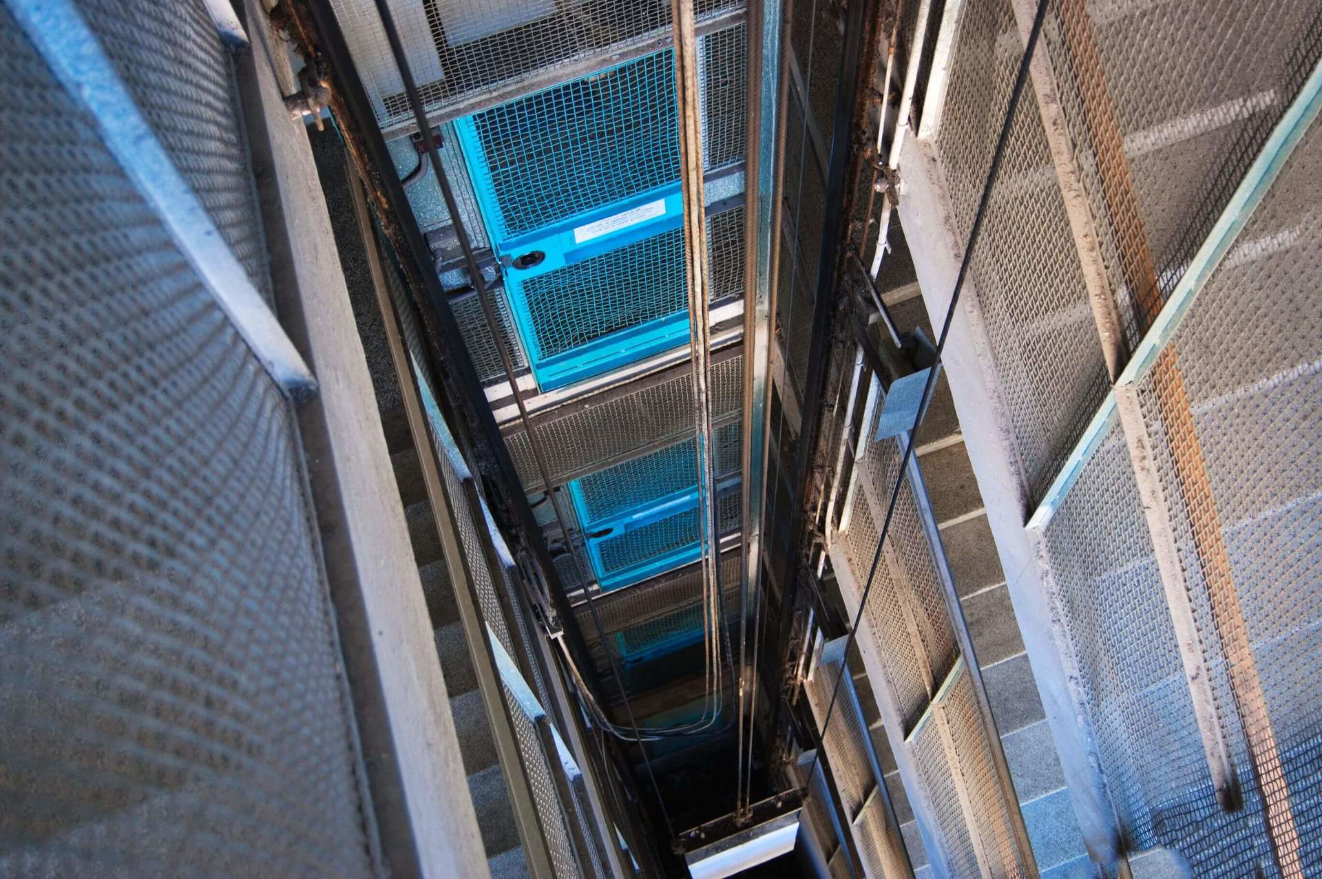 Un ascensore percorre uno stretto corridoio tra due edifici.