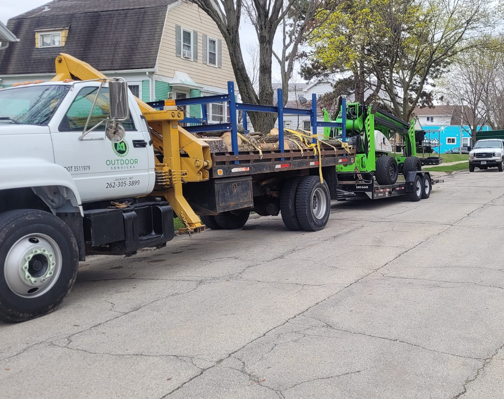 Two tow trucks are parked on the side of the road.
