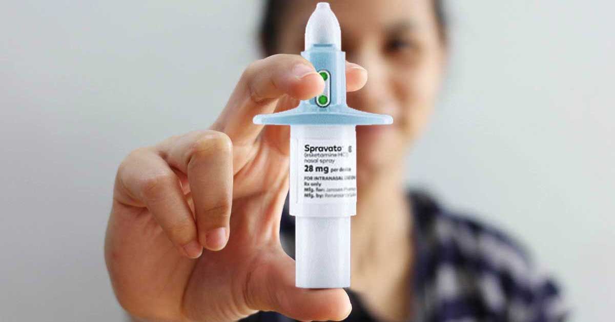 A woman is holding a nasal spray in her hand.