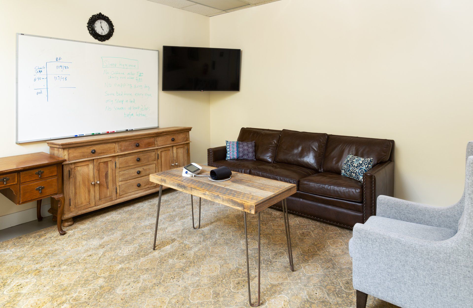 A living room with a couch , chair , table and television.