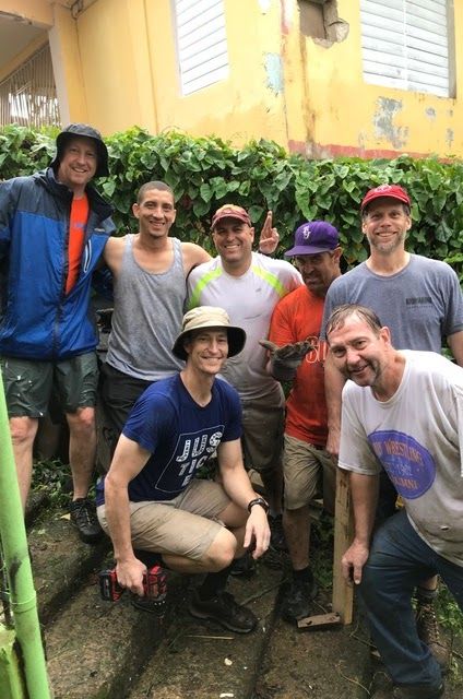 A group of men are posing for a picture in front of a building.