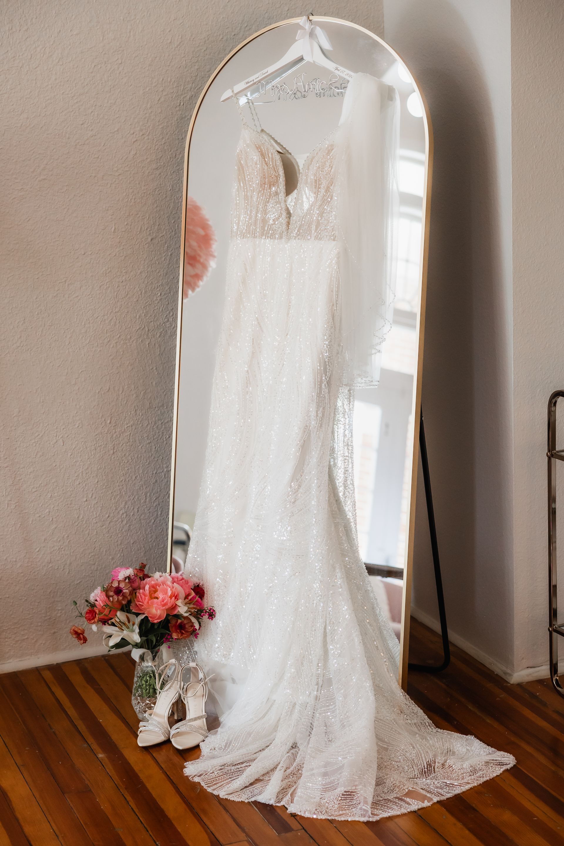 Wedding dress hanging in front of mirror