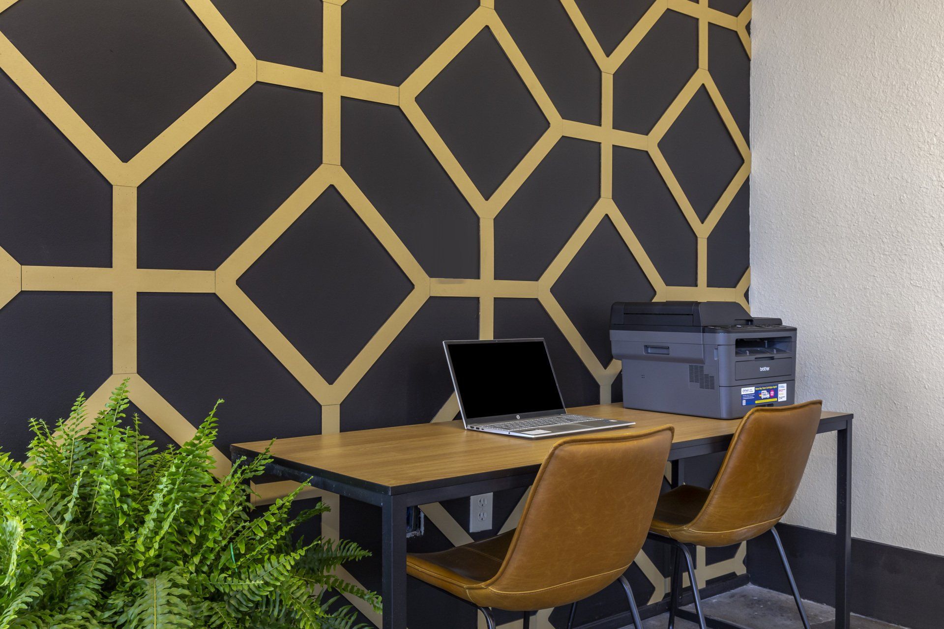 A desk with a laptop and a printer on it