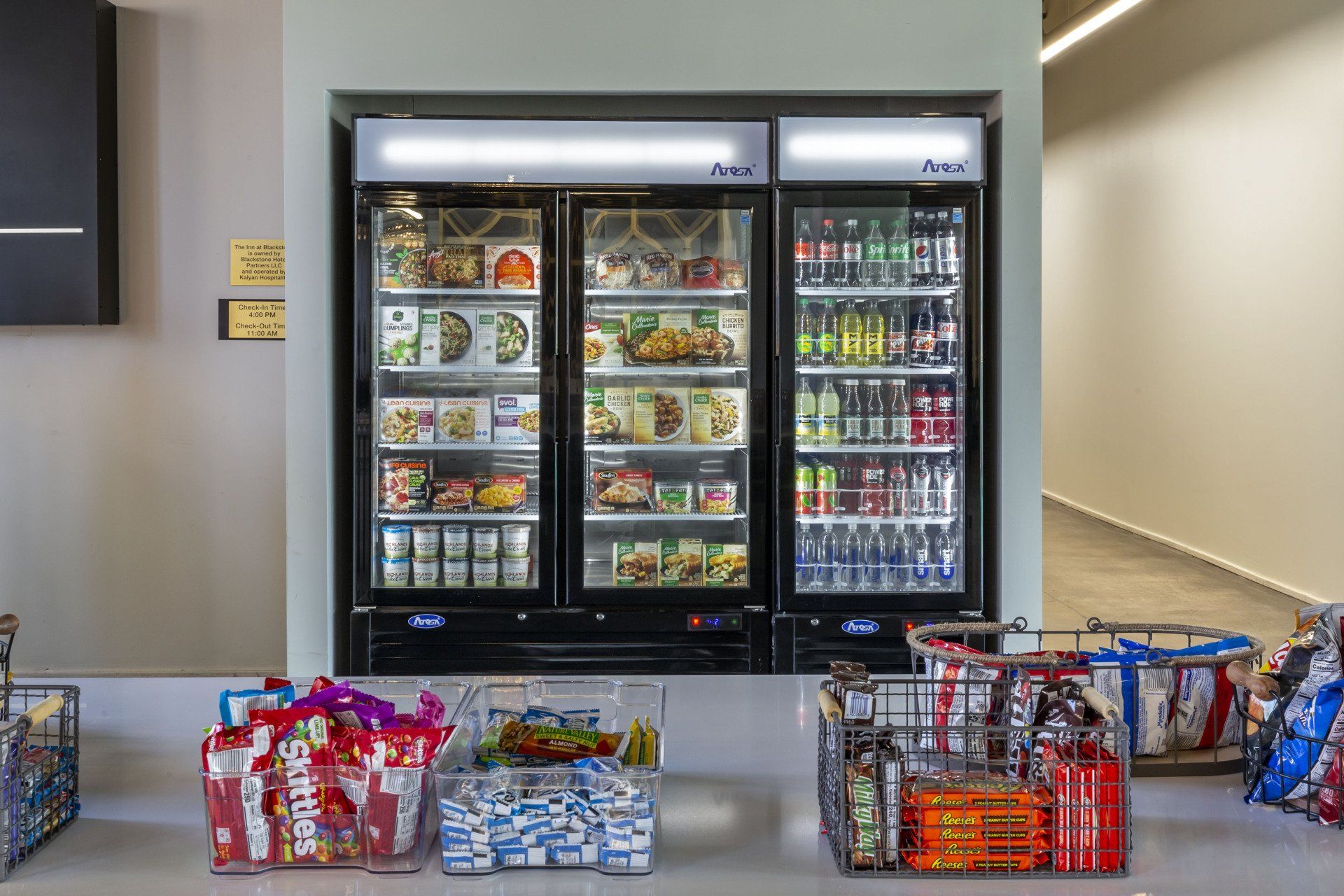 A snack bar with two refrigerators filled with snacks and drinks.
