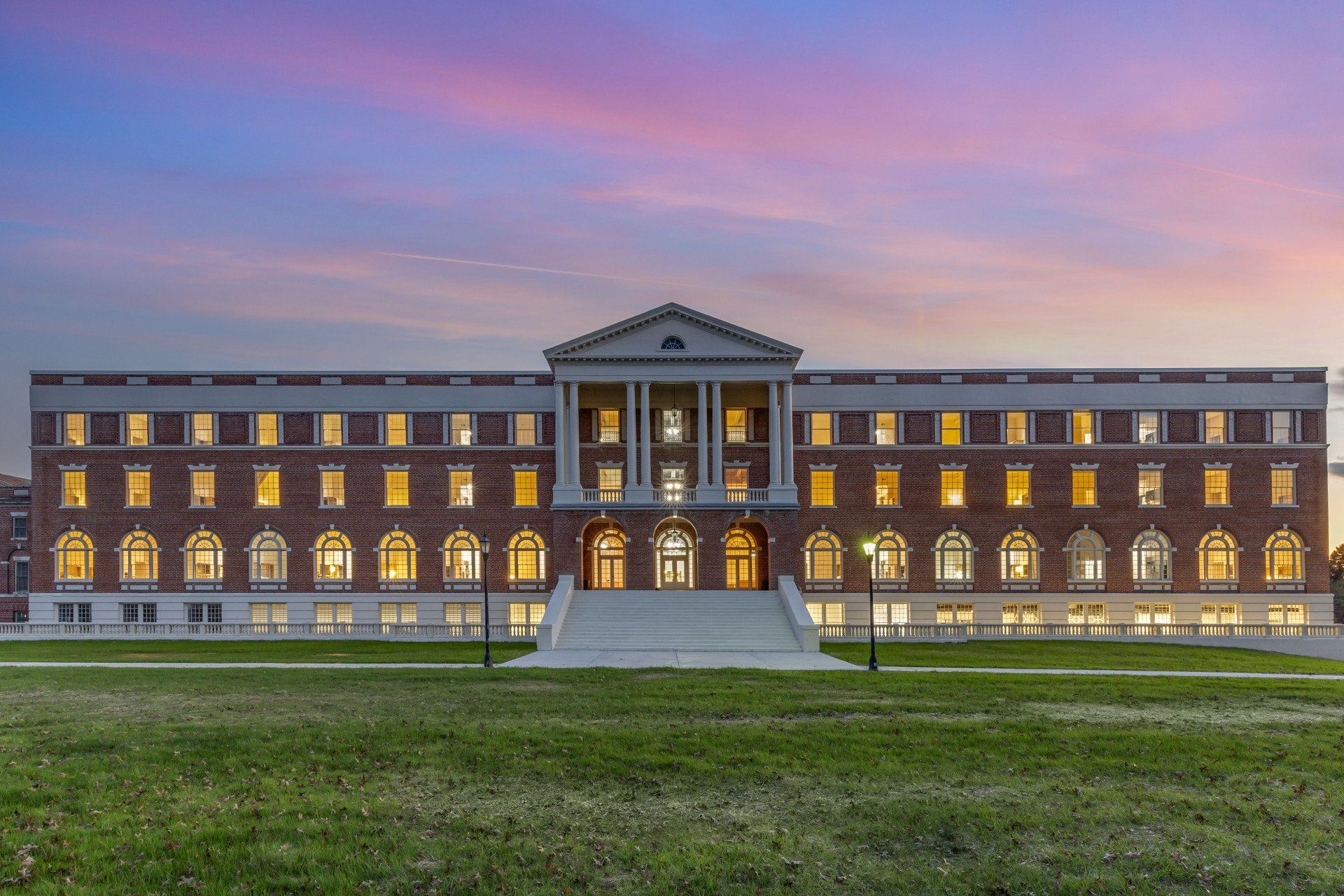 A large brick building with a sunset in the background