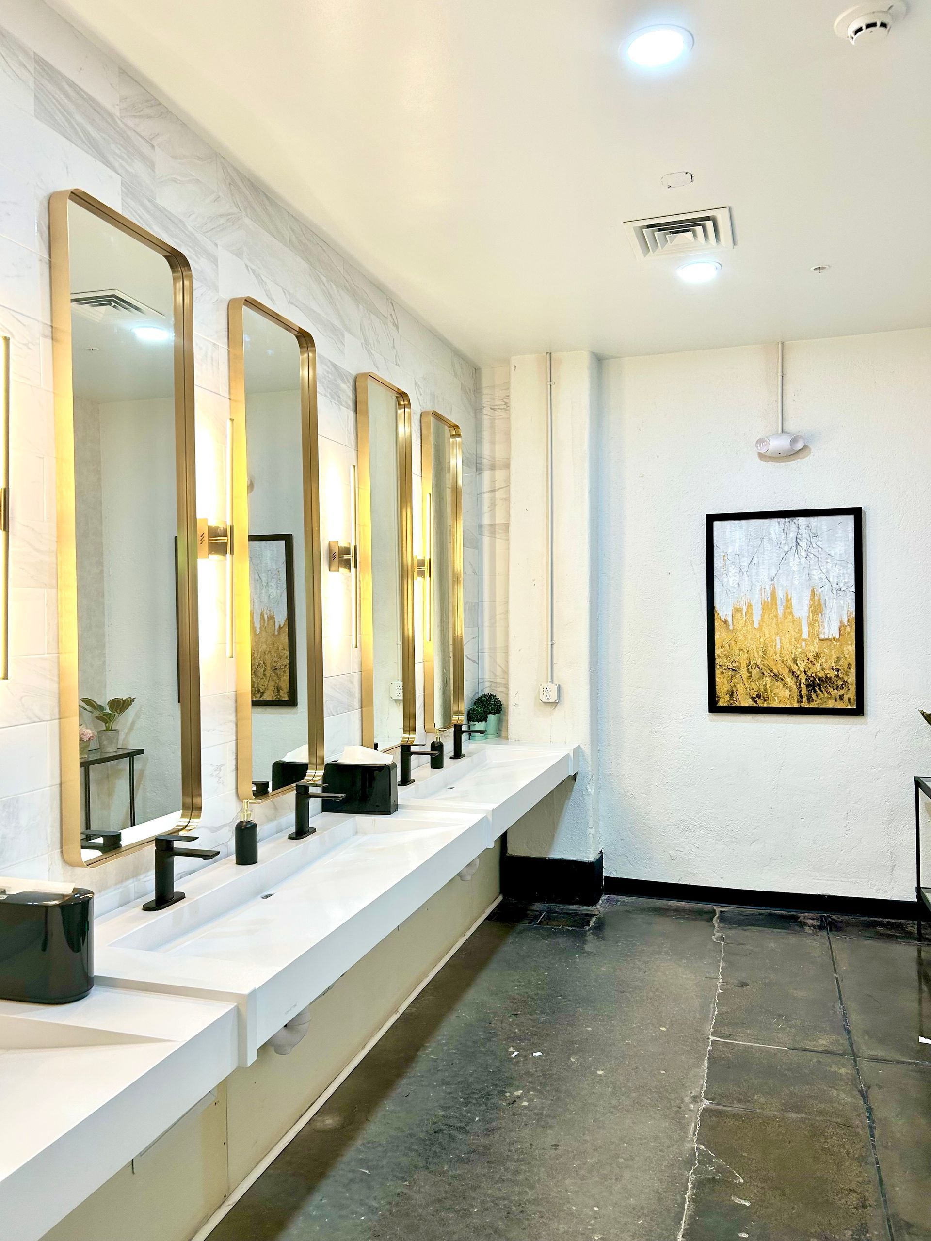 A bathroom with a row of sinks and mirrors.