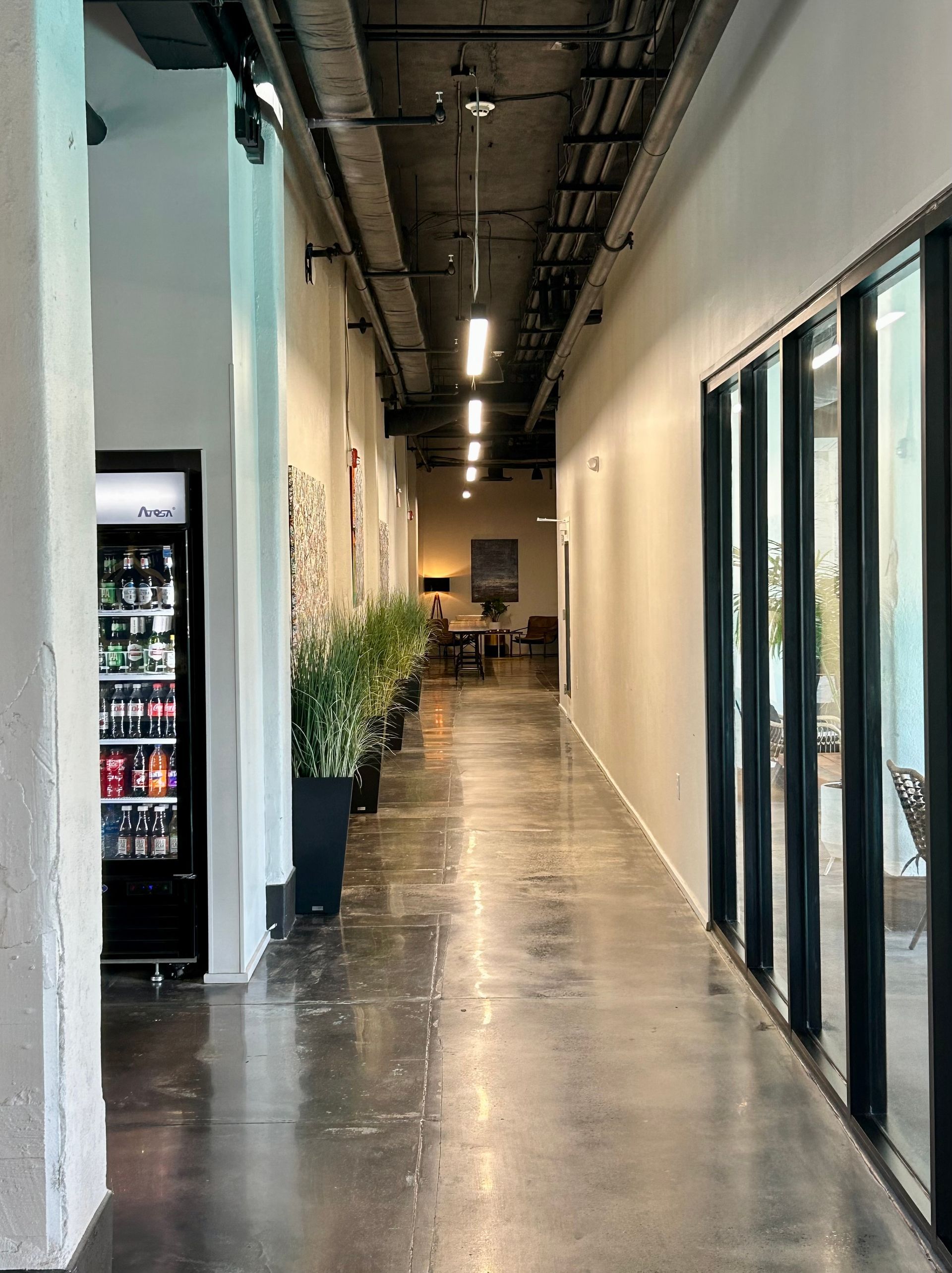 A long hallway with a fridge in the middle of it