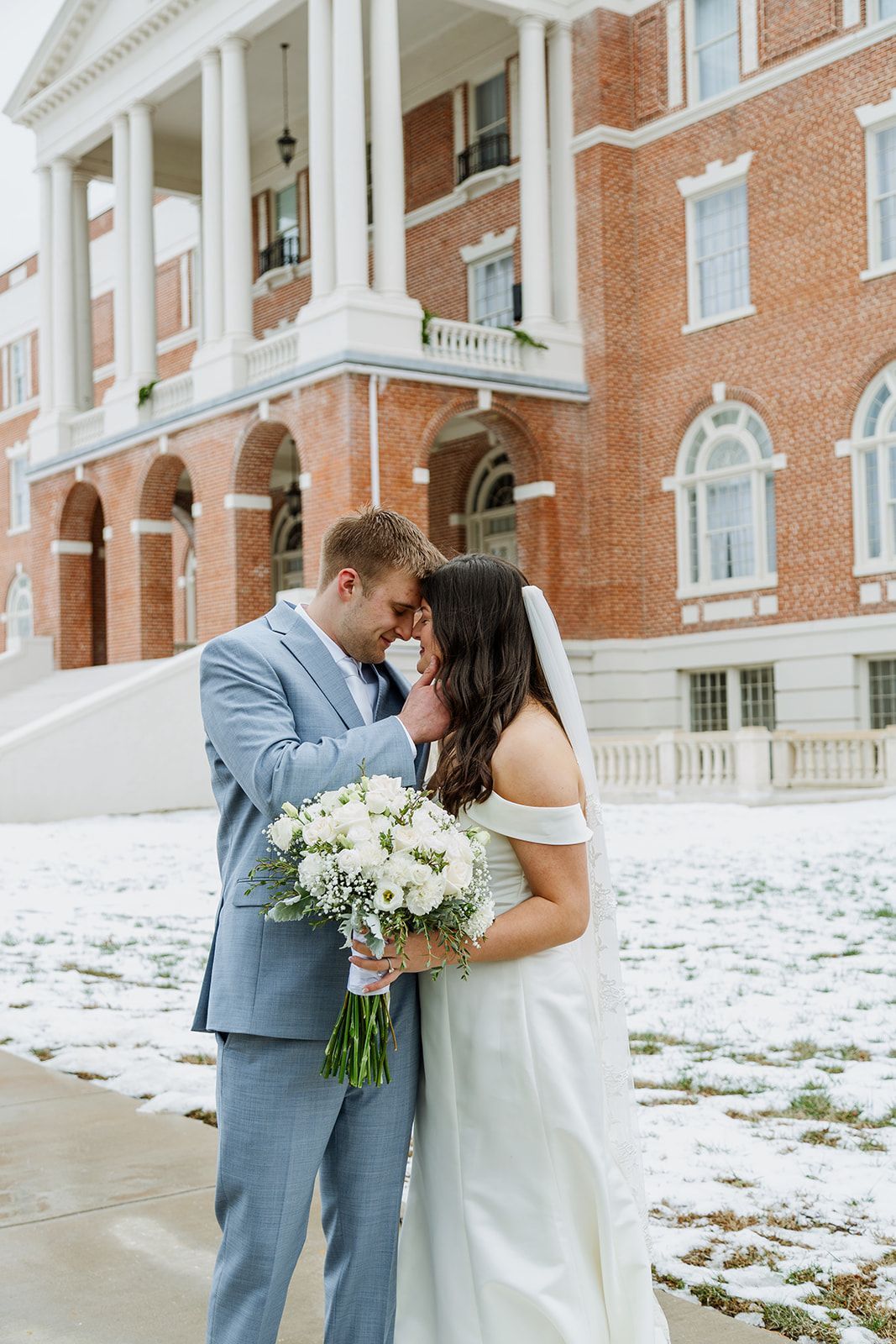 A bride and her bridesmaids are holding bouquets of flowers and laughing.