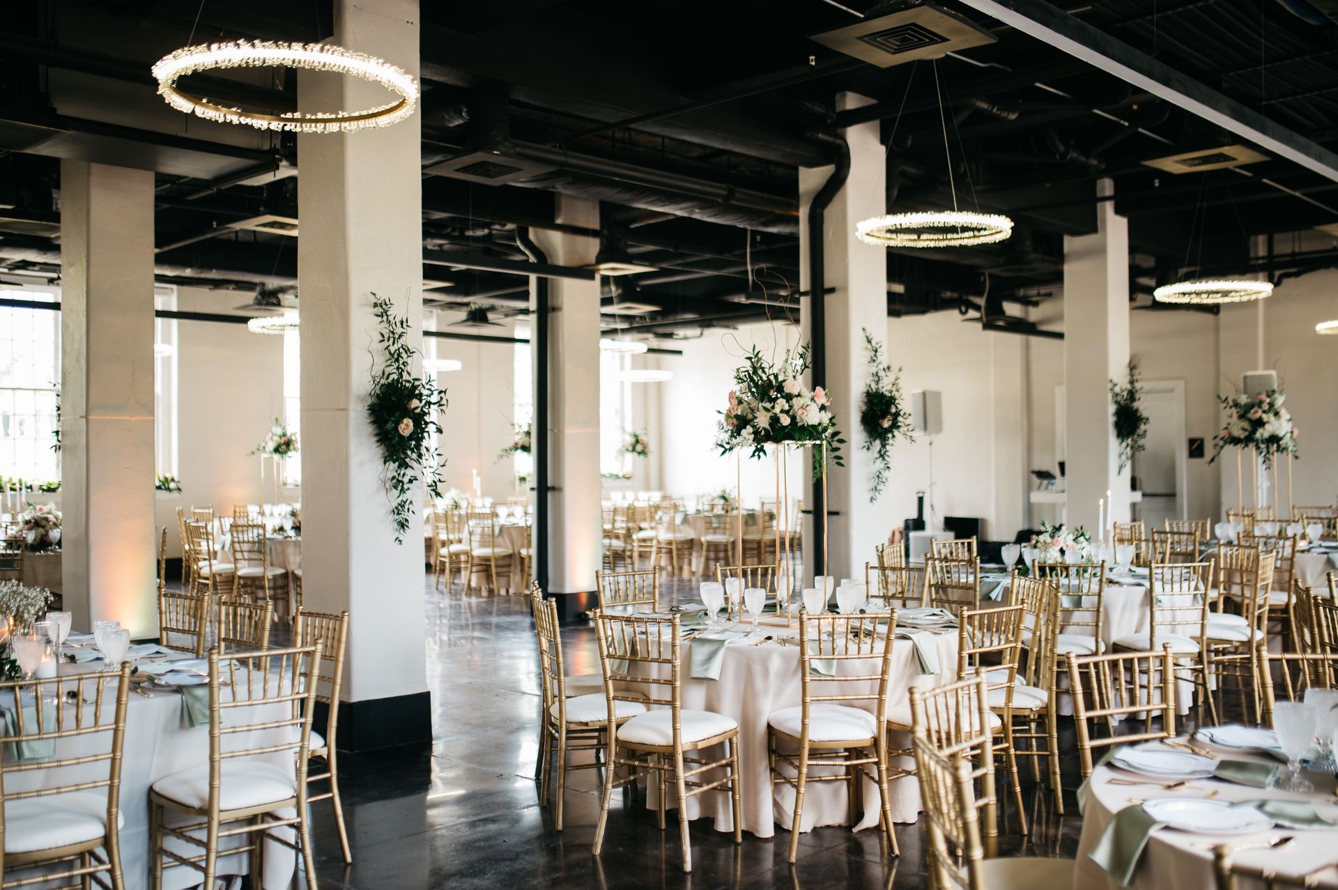 Ballroom event space decorated for a wedding with florals and tables