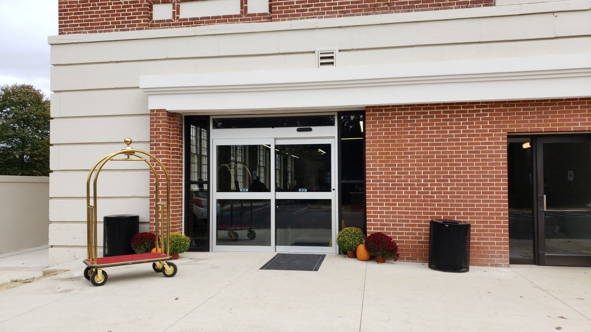 A brick building with a luggage cart in front of it