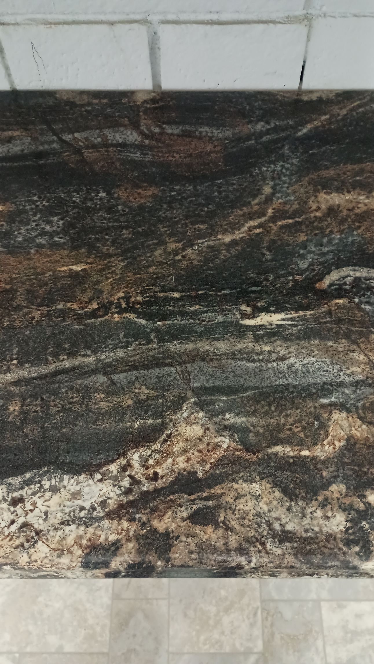 Close-up of a countertop with dark brown, black, and beige swirling patterns.