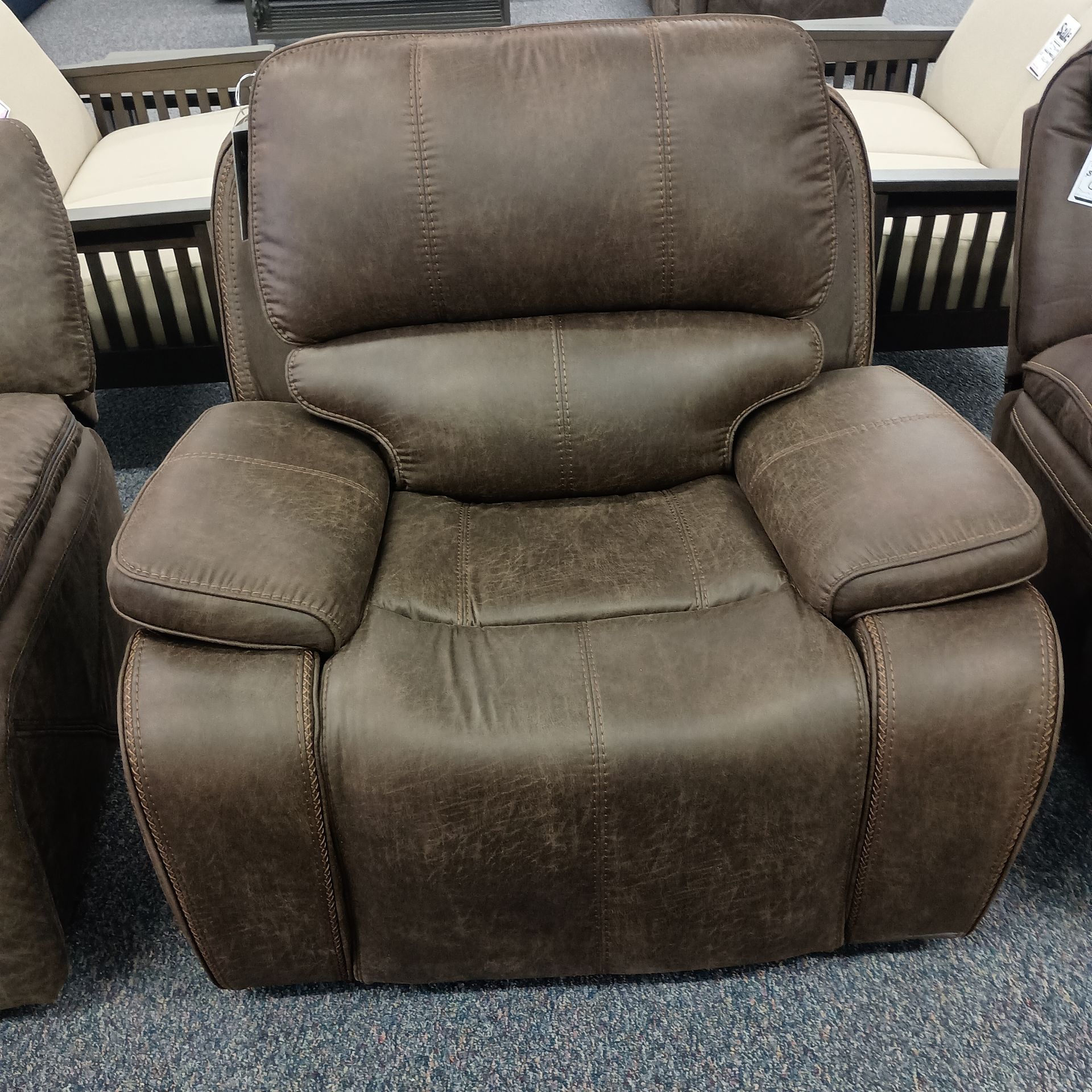 Brown leather recliner chair with stitched details.