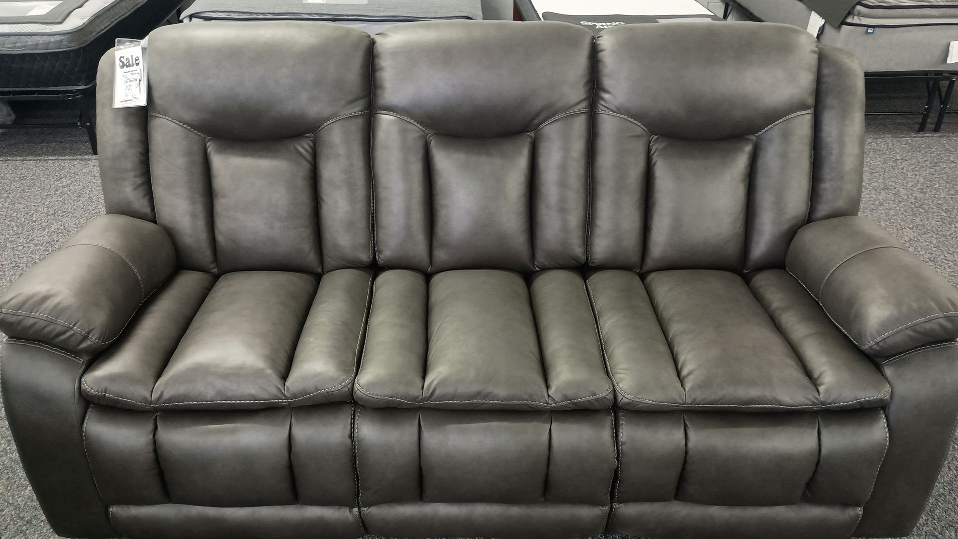 Gray leather sofa with three seat cushions