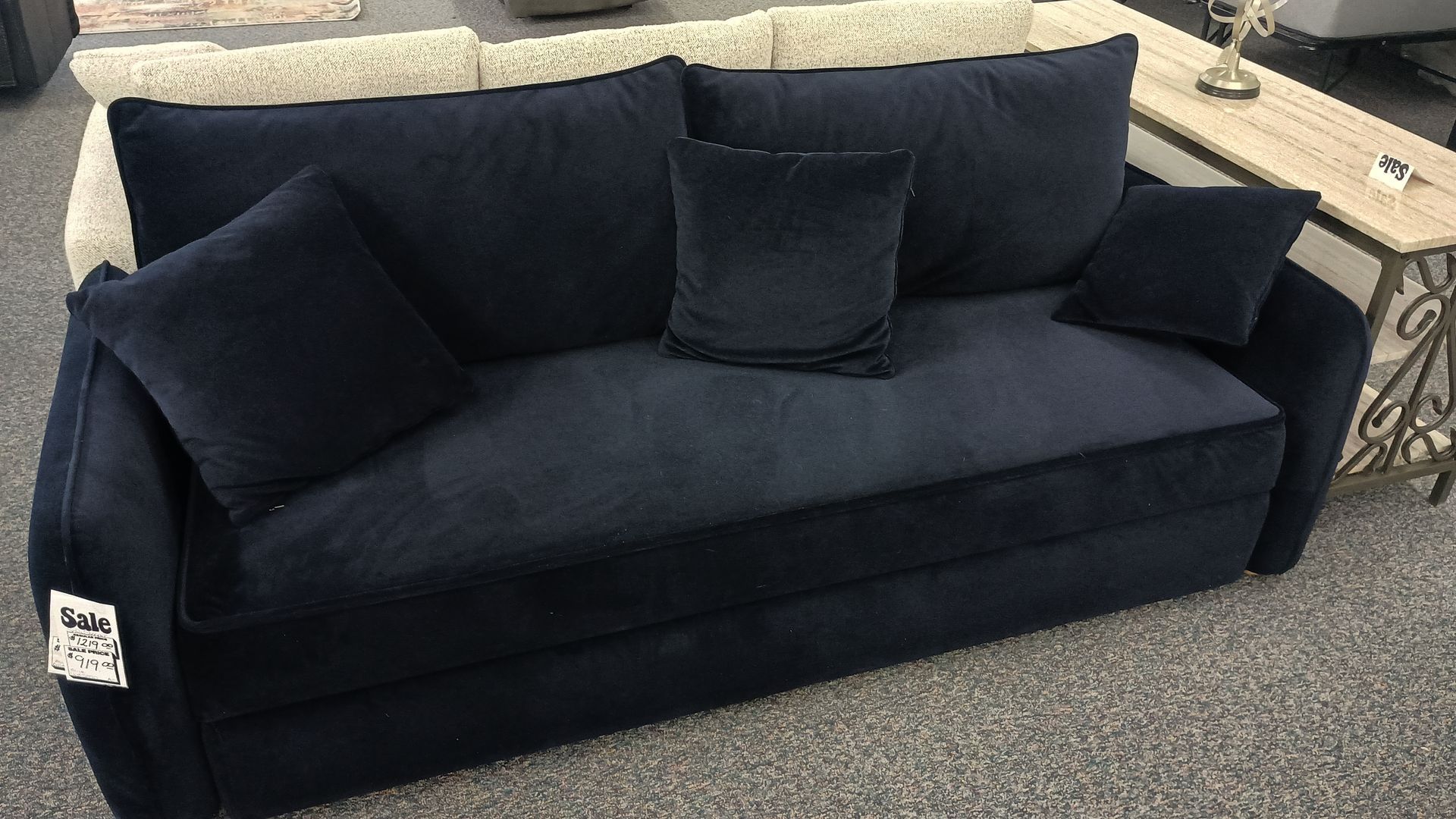 Navy blue velvet sofa with four pillows