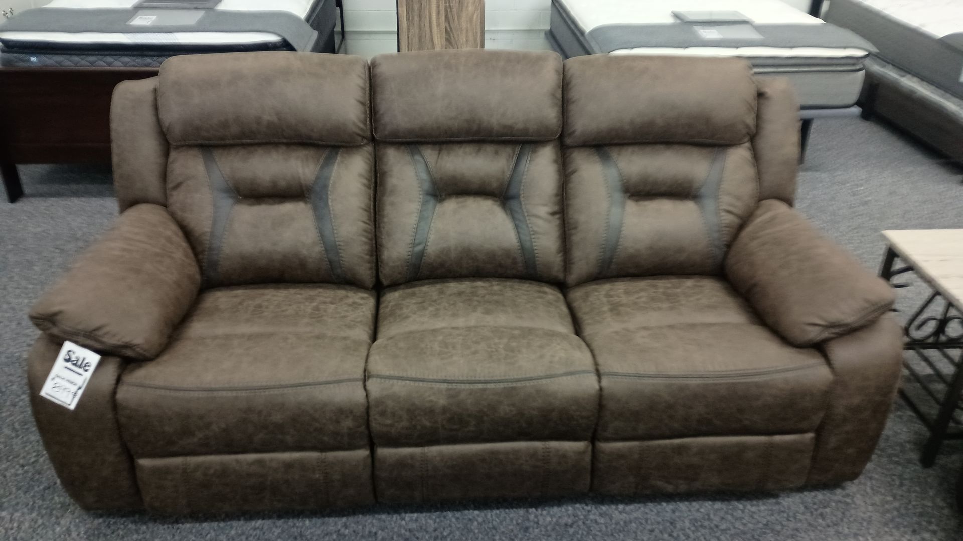 Brown leather reclining sofa in a furniture store.