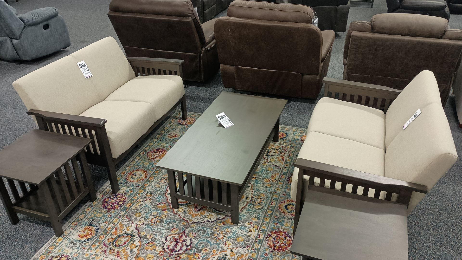 Living room furniture set with beige sofa, chairs, and brown tables.