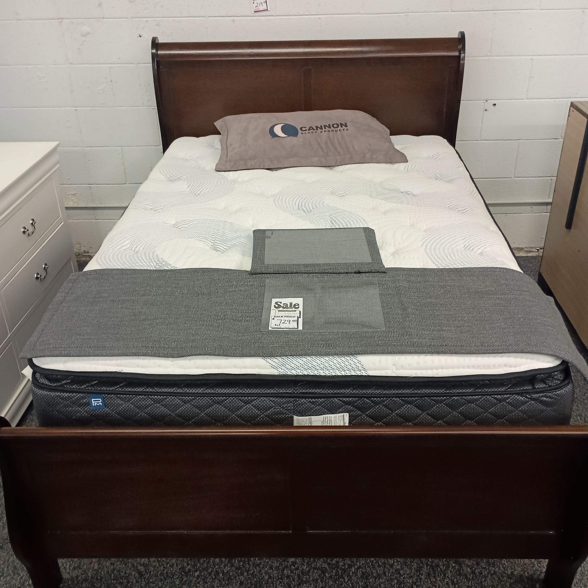 Brown sleigh bed with a mattress