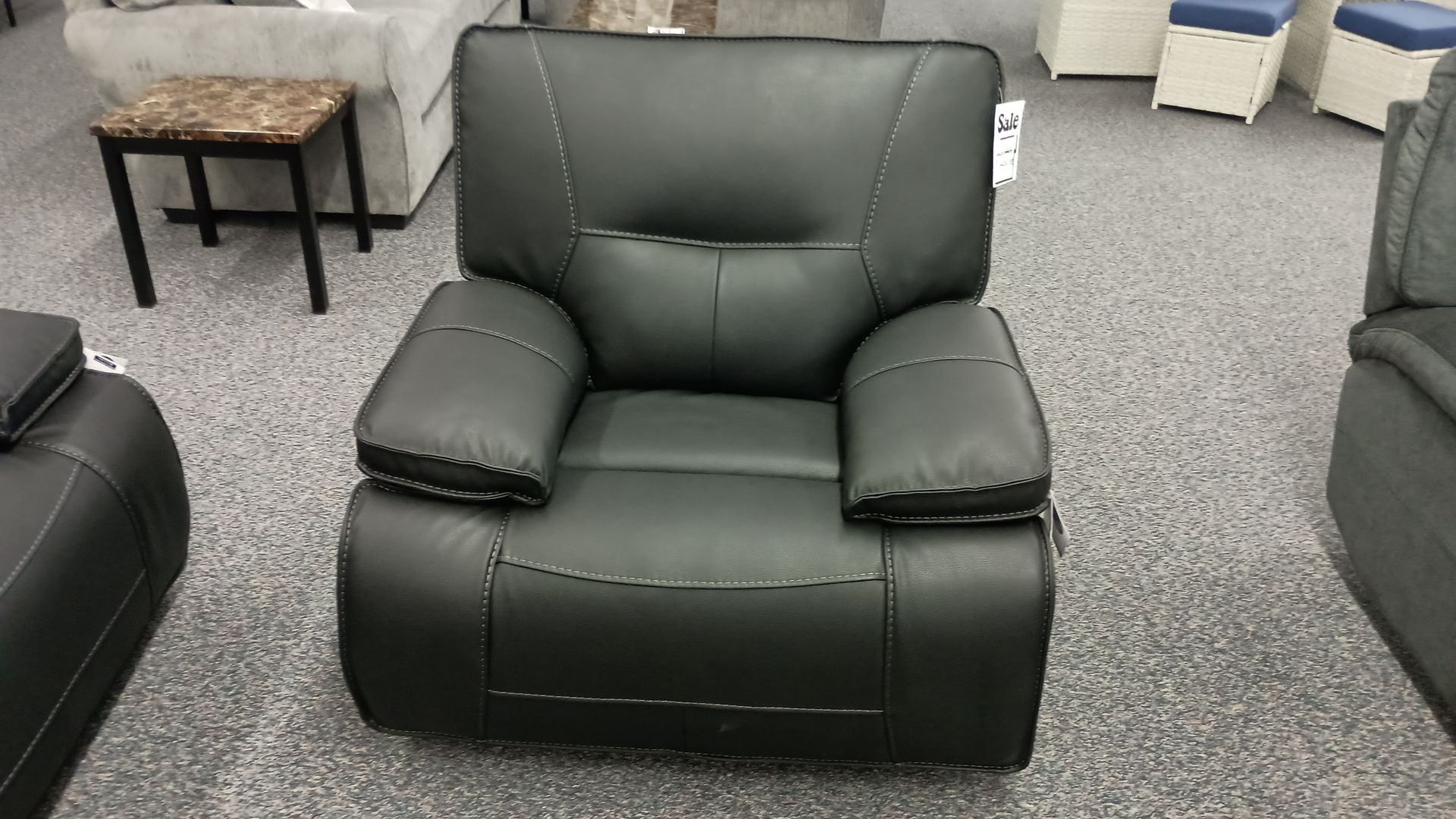 A black leather recliner is sitting in a living room