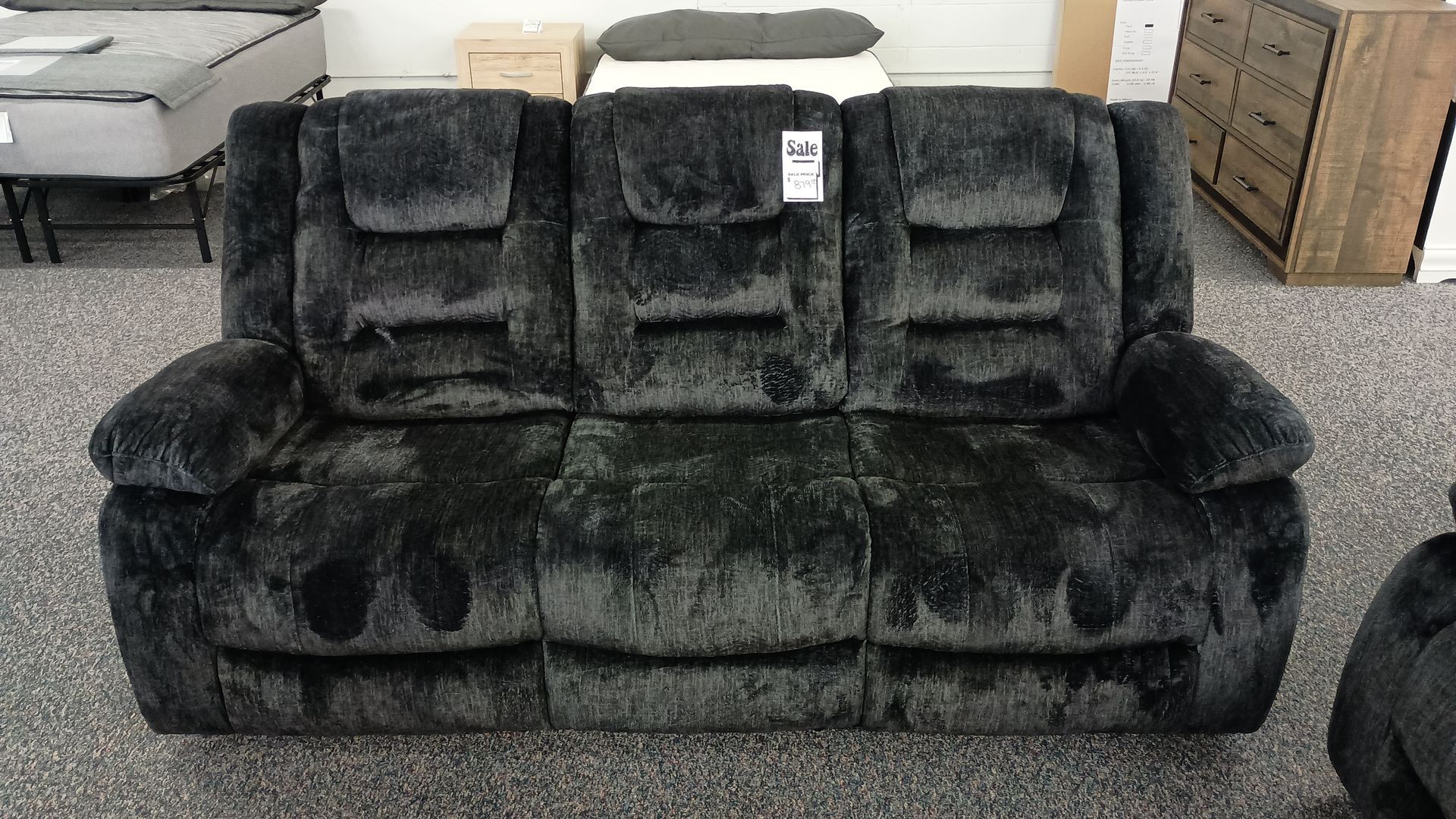 A black couch with a price tag on it