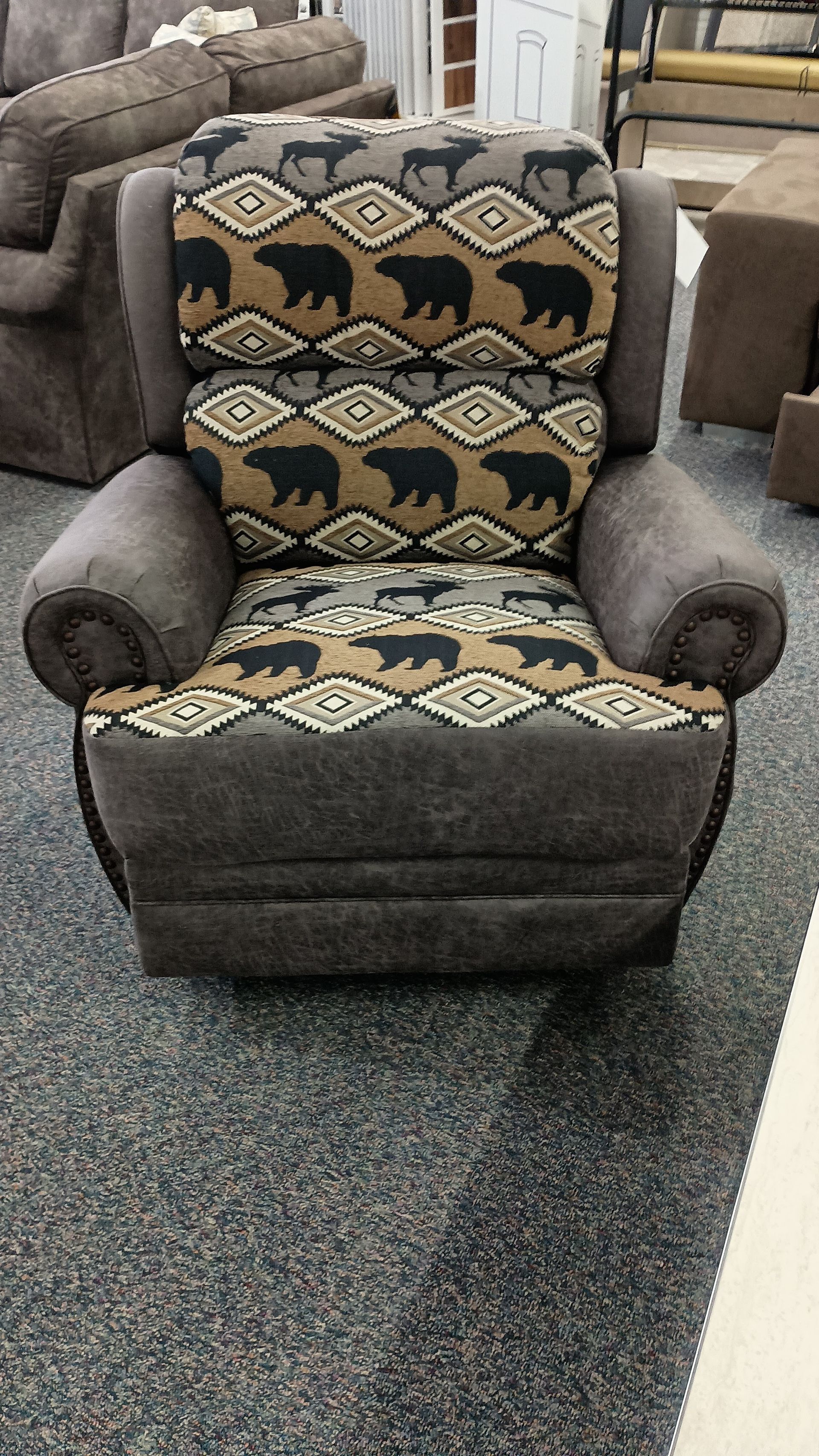 A brown recliner with a bear pattern on it
