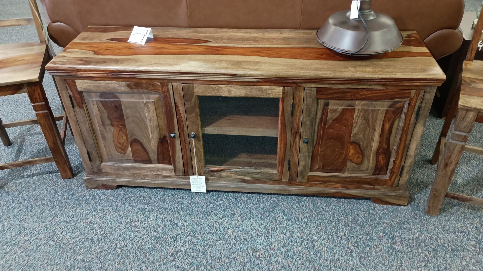 A wooden entertainment center with a lamp on top of it